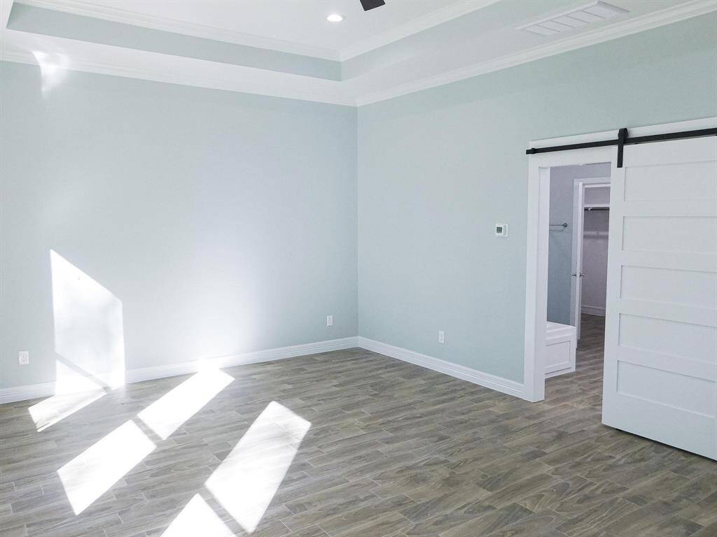 Primary bedroom. Note; tray ceiling with ceiling fan and lights.