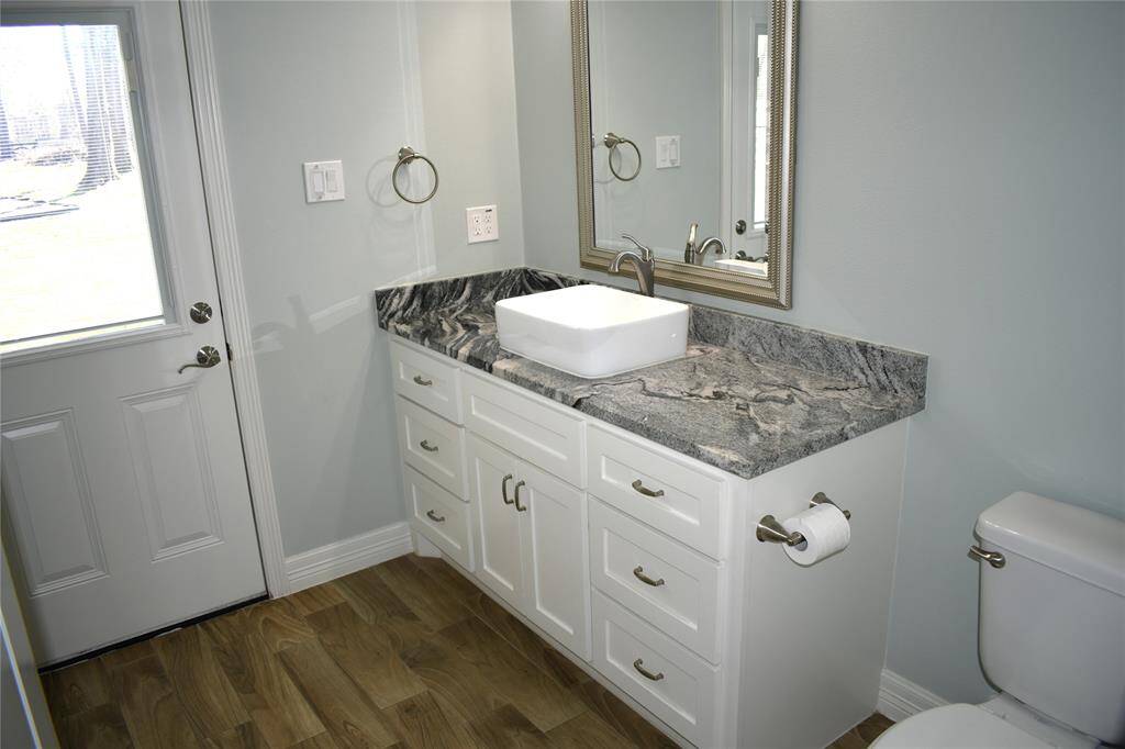 Guest restroom with back yard access adjacent to utility room.