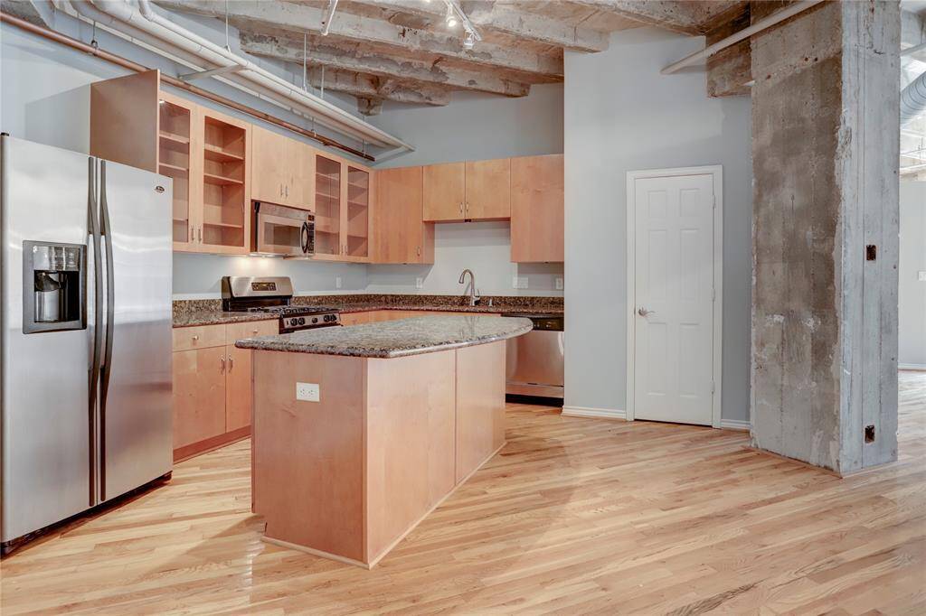 Showcasing the kitchen, you'll find a spacious island perfect for entertaining guests while you cook. It’s a great spot for gathering and socializing. To the right, there’s a large pantry, providing plenty of storage for all your kitchen essentials.