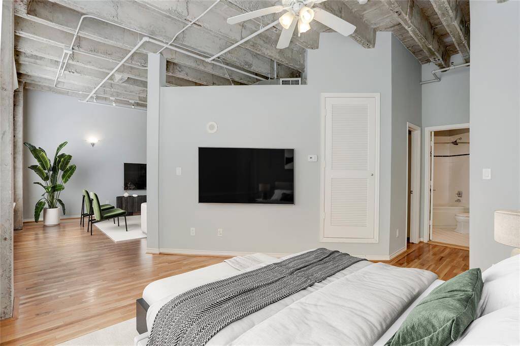 From another angle, this true loft showcases its expansive layout. The large windows on the left flood the room with abundant natural light, enhancing the bright and open atmosphere. This photo is virtually staged.