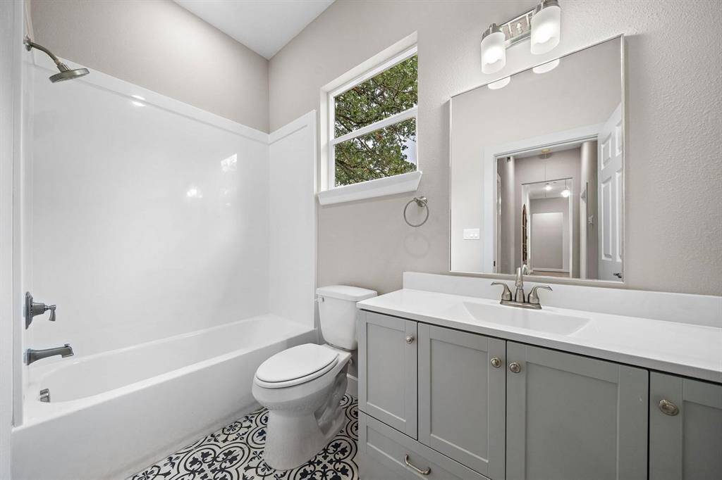 Baths 2 and 3 both contain the same gorgeous blue and gray patterned tile, 48 in vanities with loads of storage, Moen fixtures, comfort height commodes, and white cultured marble tub surround. No grout lines to clean!