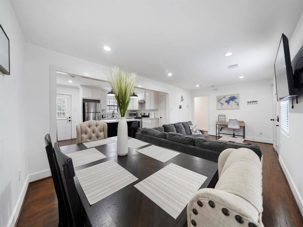 Open concept living space with wood floors throughout and windows allowing for natural light.