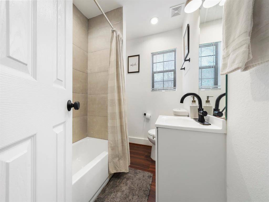 Secondary bathroom with tub/shower combo and modern black fixtures.