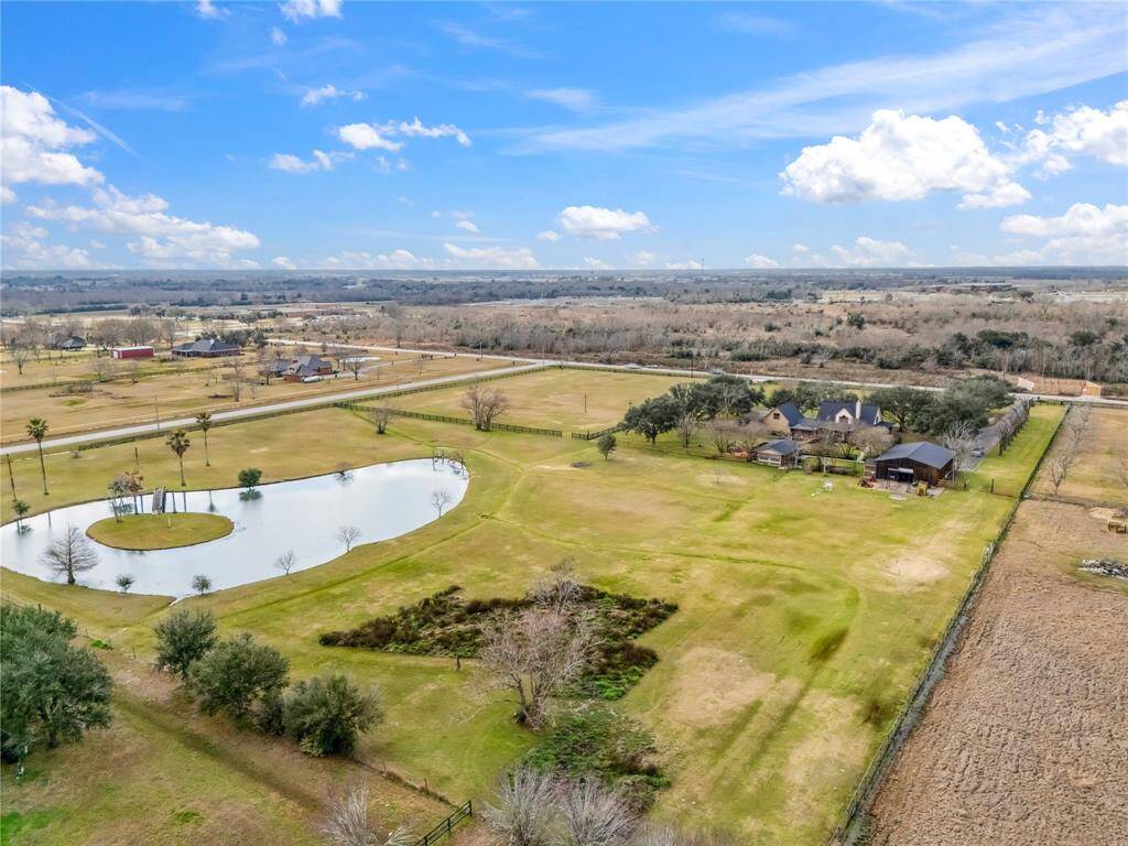 Massive 11+ acre country property with everything you could ever need: fully fenced, main house, barn/workshop with small apartment, BBQ house with full kitchen, mature oak trees and bass pond.