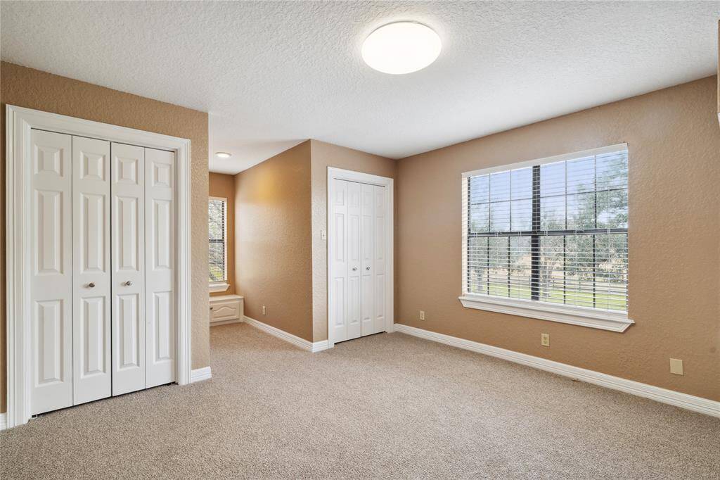 Secondary bedroom upstairs is bright, newly carpeted and has a large window offering a scenic view, perfect for a cozy and inviting space.