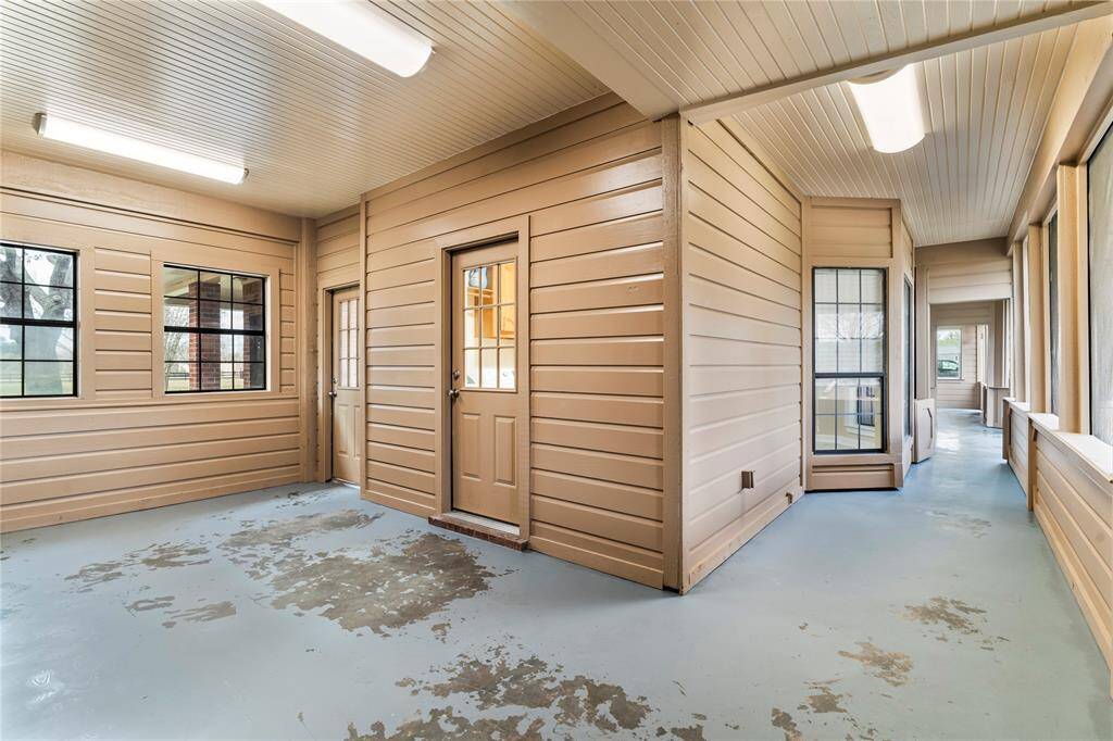 Enclosed back porch has plenty of lighting.