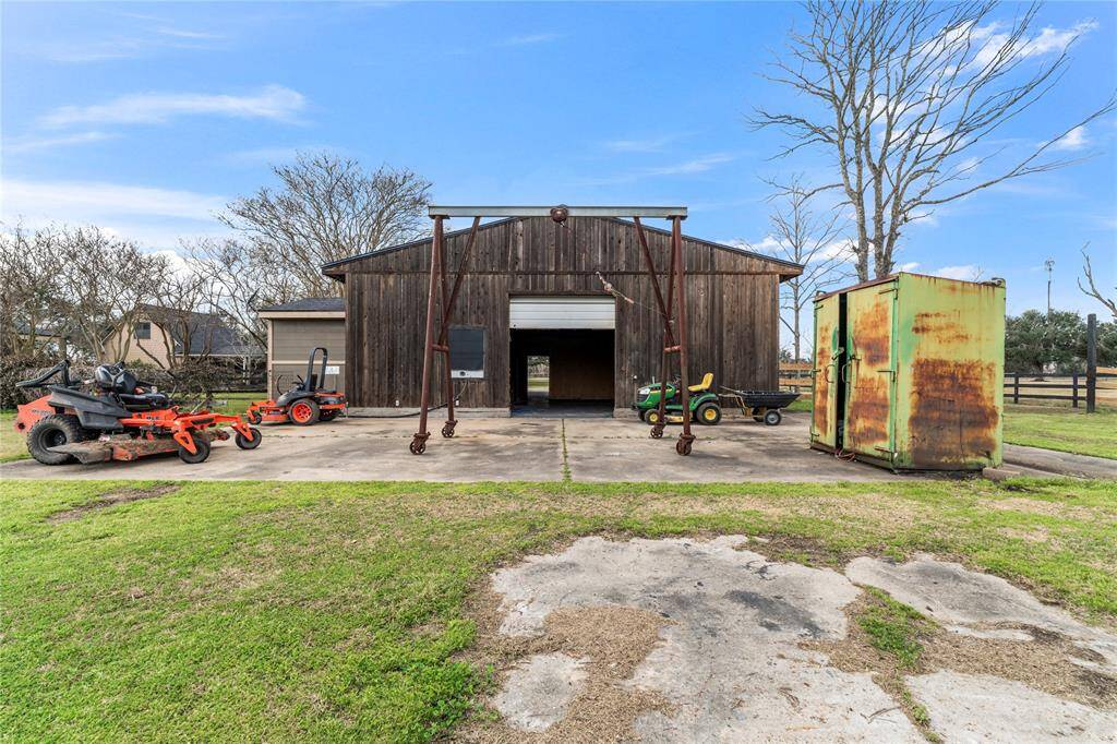 Rustic wooden barn surrounded by greenery is ideal for buyers seeking a property with ample outdoor storage and workspace.