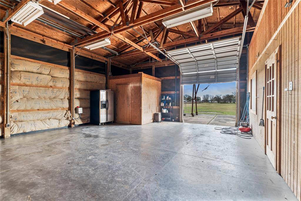 Workshop/barn is massive with roll up door. Plenty of space for farm equipment, tools, etc.