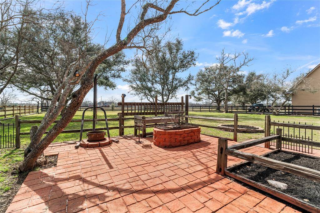 Fire pit area is fenced in and sits right outside of BBQ house.