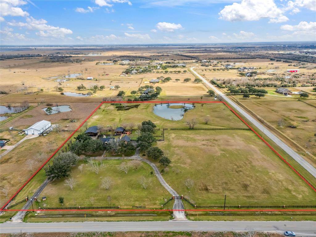 11+ acres of country property with open fields, a pond, and mature trees.