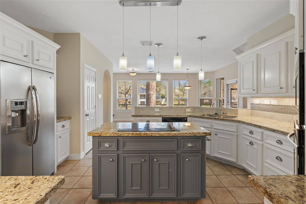 The beautiful kitchen is a true showstopper, featuring white cabinetry, a contrasting gray island.