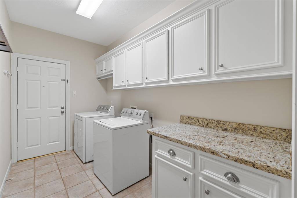 The large laundry room offers tons of cabinets and ample counter space for folding clothes, conveniently located right off the garage for easy access and functionality