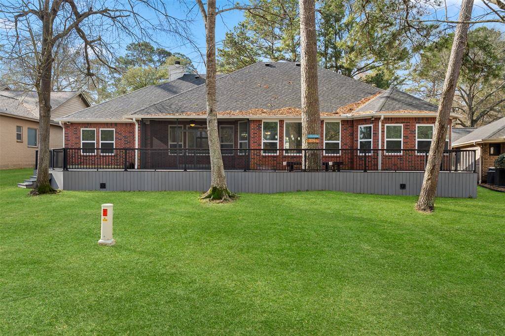 The view from the golf course showcases the back of the home, featuring the amazing screened-in porch and large new Tyvek deck, perfectly positioned to enjoy the serene golf course setting