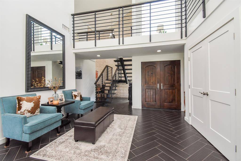 Greetings as you come inside to the front entry with sitting area. Notice the custom open stringer architectural stairs with 2" solid Cypress threads