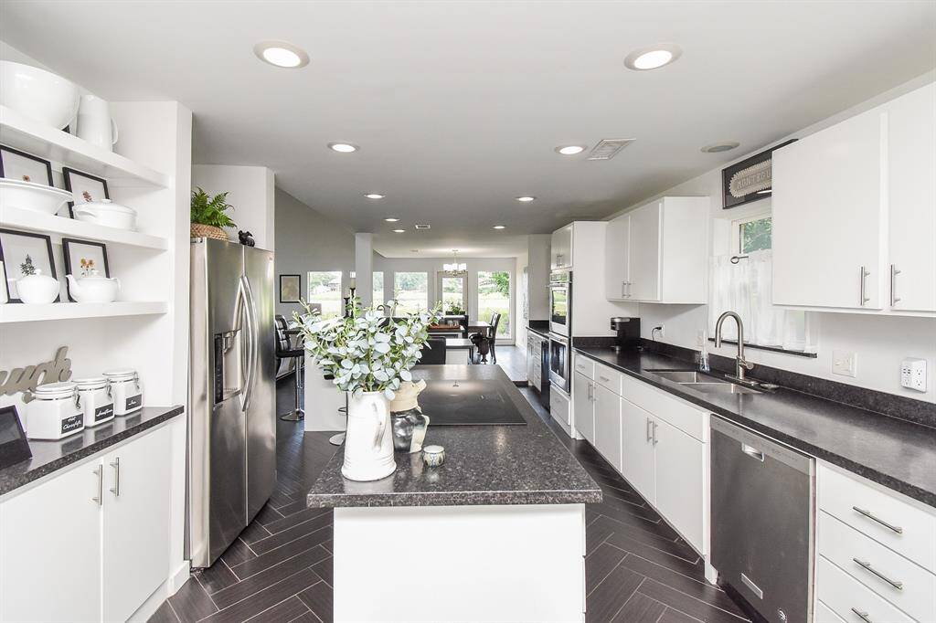 Large island and long counters make food prep a breeze.  You will love the leathered Black Pearl granite counters that don't show fingerprints. Yes please!