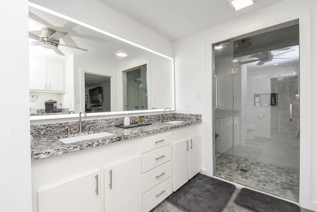Primary ensuite bath with highly custom shower, back lit mirrors, granite counters, soft close drawers and cabinets