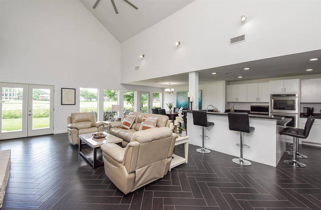 Better view of the wall of windows that bring the outside in with golf course and lake views.All windows except for the 4 fixed windows in the rear were replaced in the remodel.Wetbar/Breakfast bar sneak peek on the right