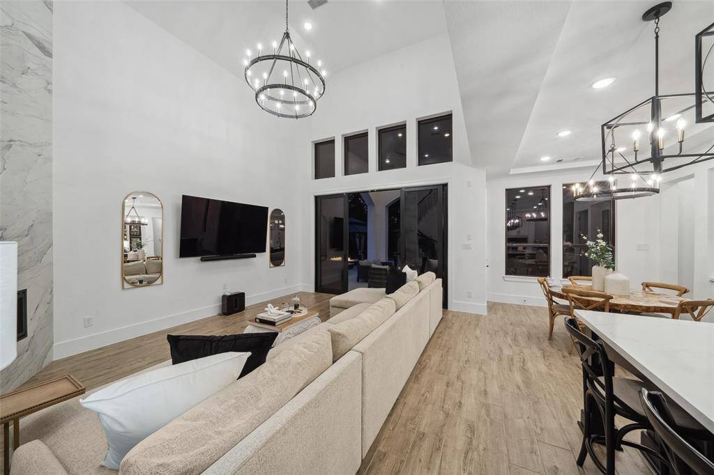 Double sliding doors open to the covered  patio and pool, seamlessly merging indoor and outdoor living