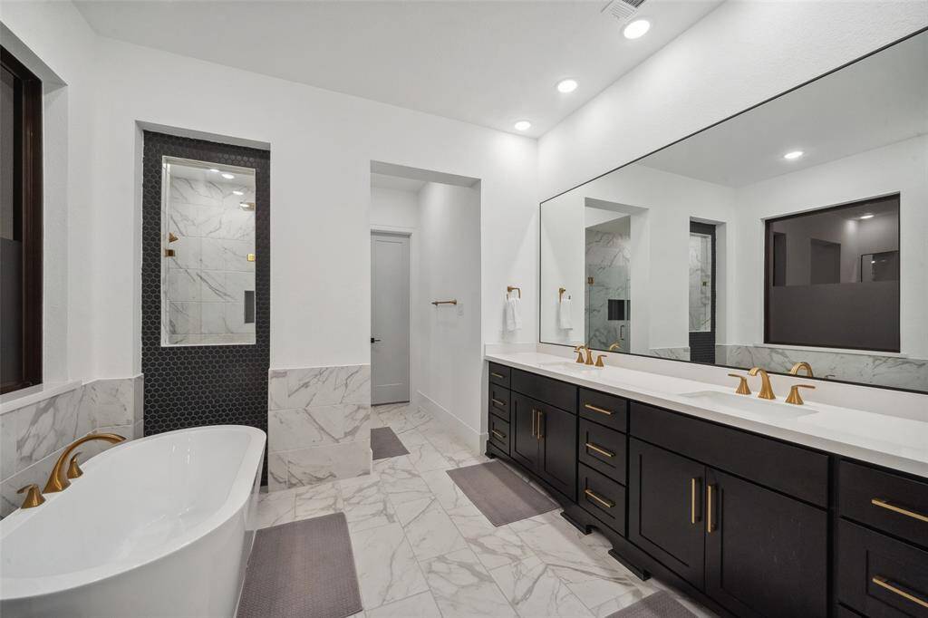 Luxurious en-suite bathroom features a soaking tub, shower, dual sinks, additional vanity space and 2 walk-in closets