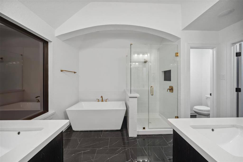 Attached bathroom features another luxurious soaking tub, walk-in shower, double vanities and generous walk-in closet