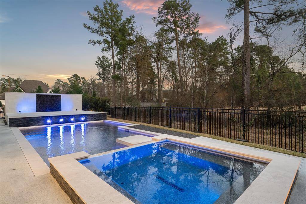 Lighted water wall creates elegance while providing privacy to the pool and oversized spa