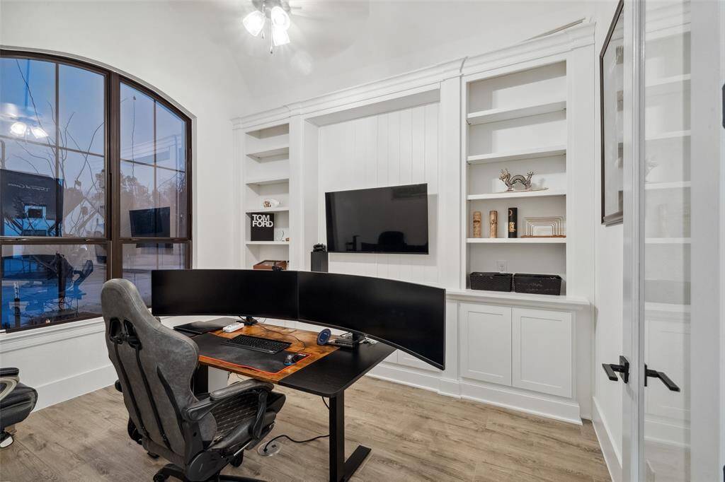 The office features custom built-ins and glass paned double doors