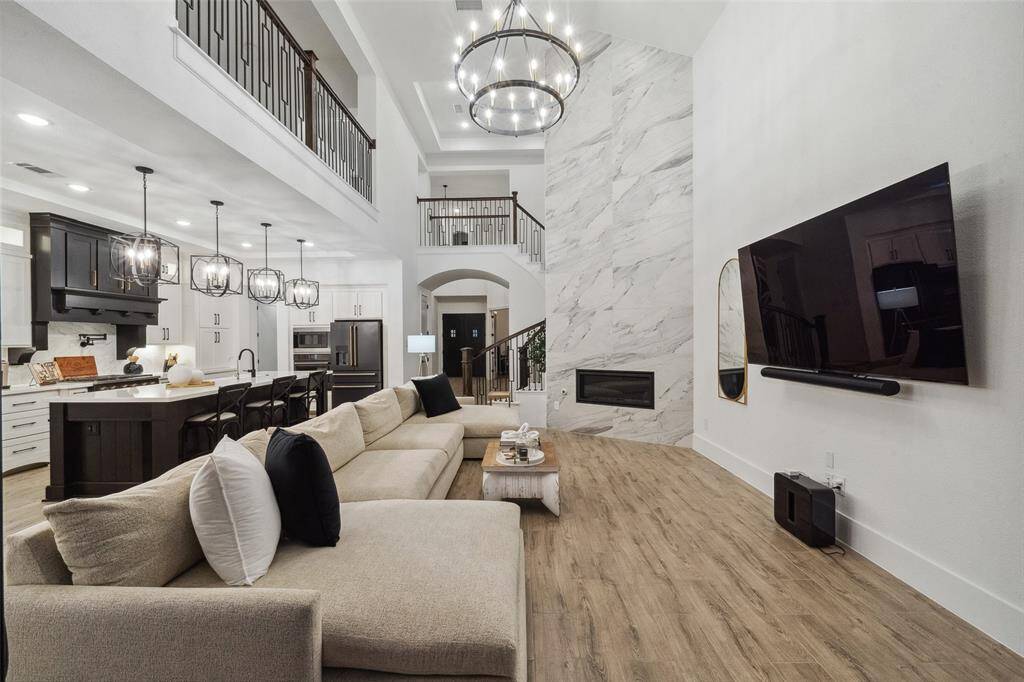 Striking floor to ceiling gas fireplace with fire glass adds warmth and elegance to the open concept space