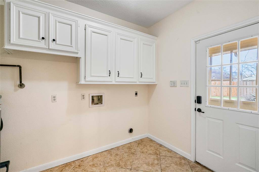 Laundry room with overhead cabinets.