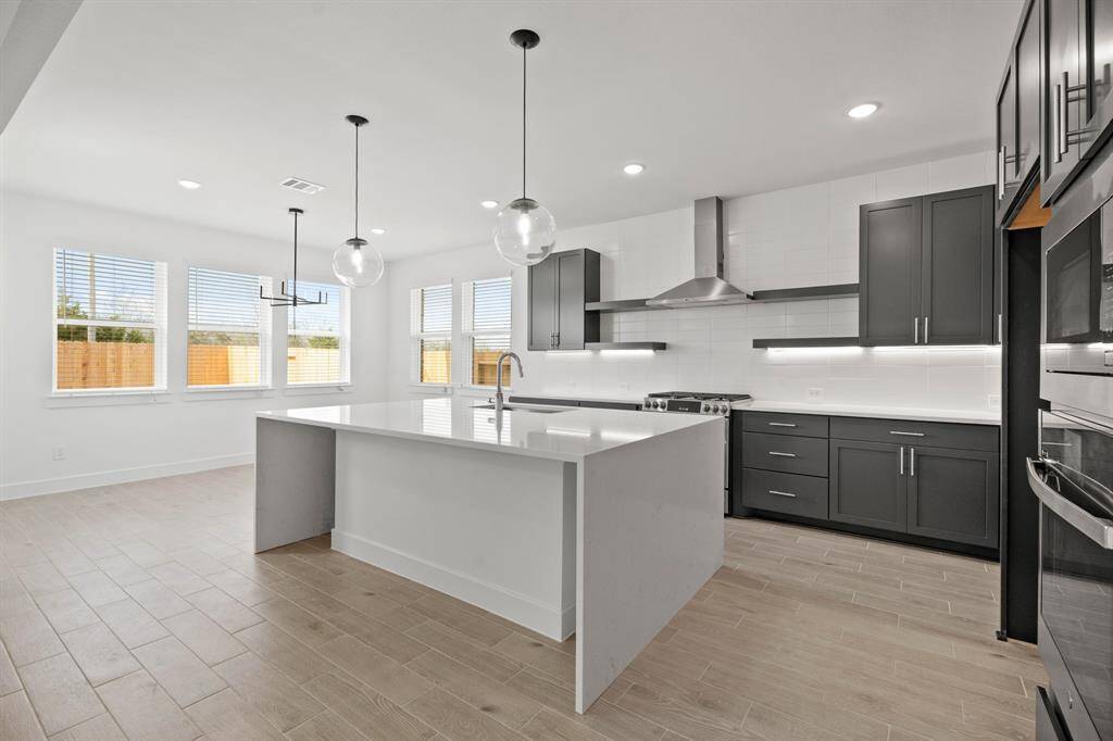 Stylish kitchen with quartz countertops and decorative floating shelves (*Photo not of actual home and used for illustration purposes only.)
