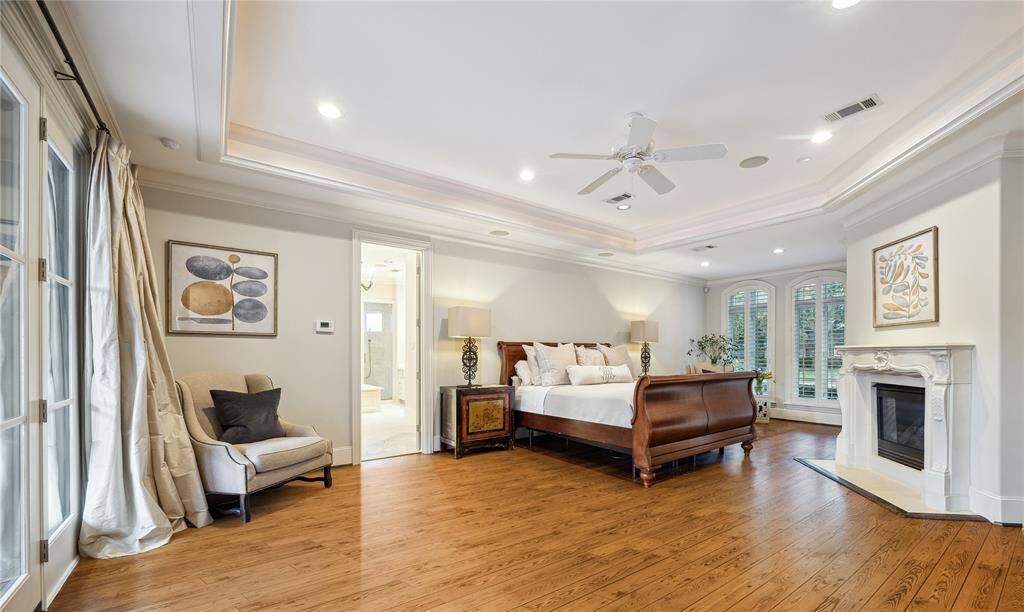 Also on the first floor, the spacious primary retreat measures an impressive 29' x 20' allowing for various furniture configurations.  Note the gas log fireplace and tray ceiling with ambient lighting.