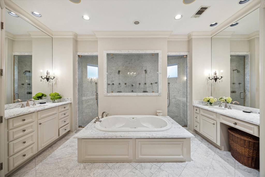 The primary bath is designed with two of everything:  two private water closets, two vanities, and an oversized shower with dual controls and two doors.