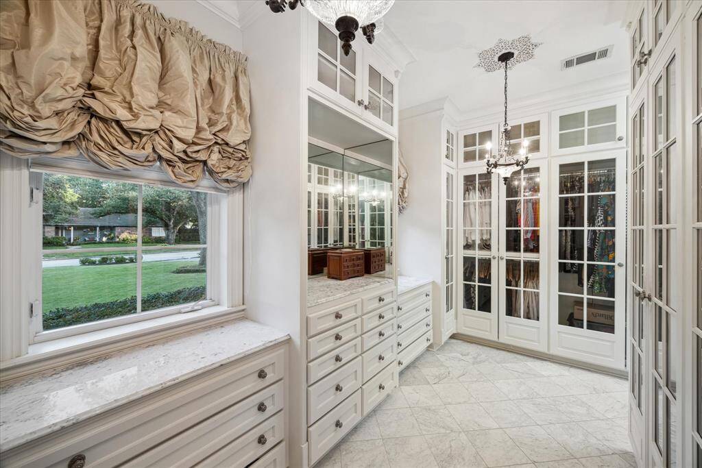 This boutique-style closet is the second of two in the primary suite, this one with with glass-fronted doors.