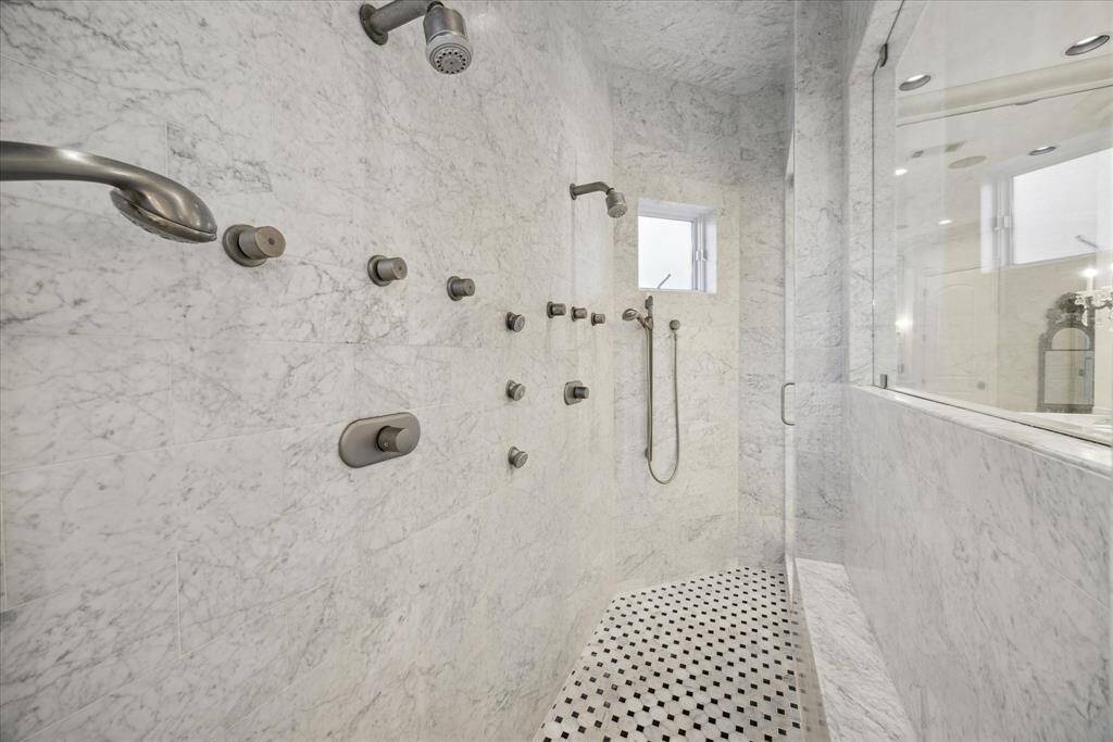 Separate shower has two sets of shower heads and doors on either end.