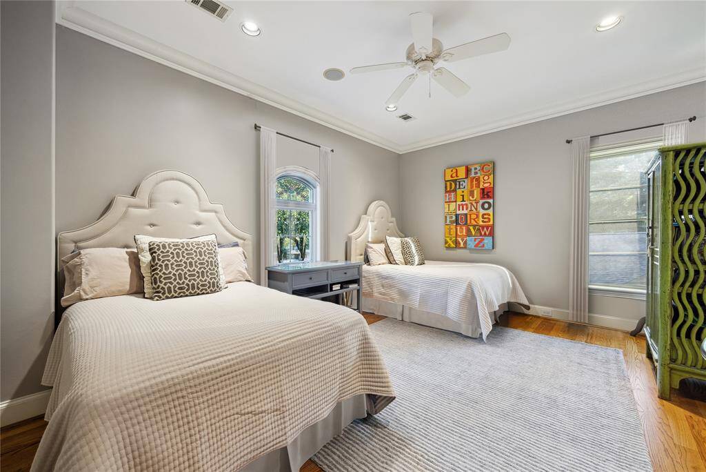 This oversized secondary en-suite bedroom comfortably accommodates two full-sized beds, writing desk, and an armoire.