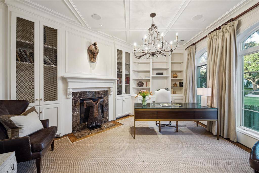 The beautifully paneled study, painted in a crisp clean cotton color, has a gas-log fireplace and custom sisal rug.
