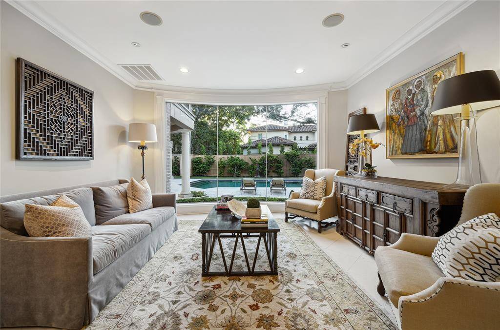 Sight lines from the front door lead directly to the formal living area, with its butt-jointed glass wall and views of the sparkling pool.