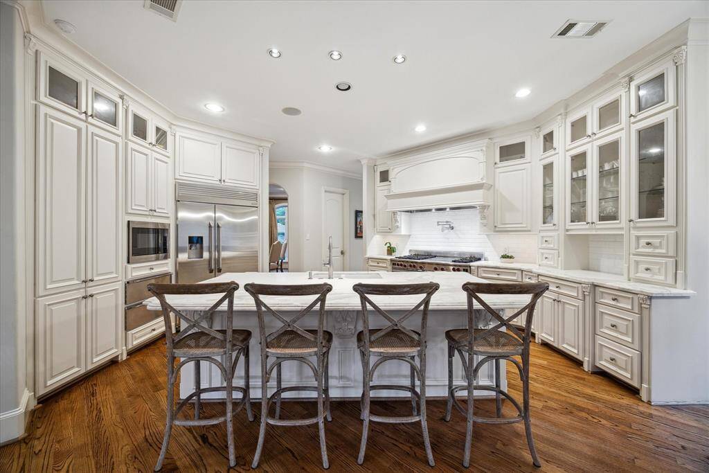 Back inside, this kitchen is a chef's dream and features a 60" commercial-grade Wolf range with pot filler above, two dishwashers, and two warming drawers.