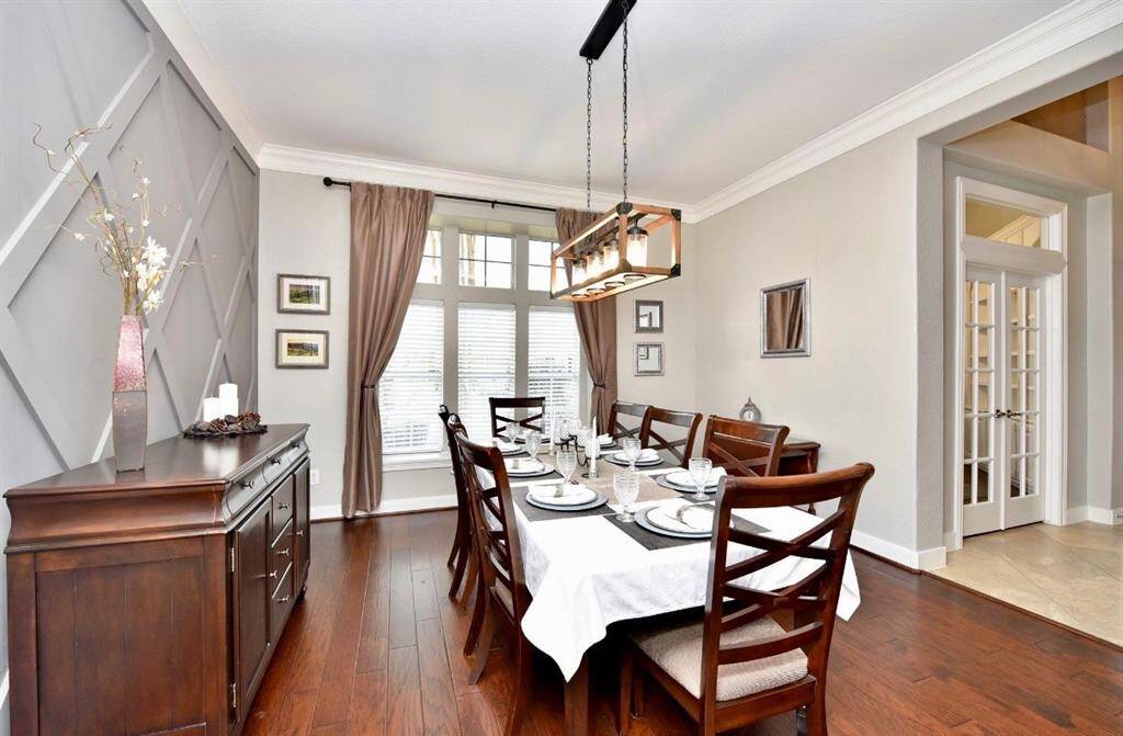 The dining room boasts engineered hardwood floors, a batten feature wall and luxe color selections and fixtures.