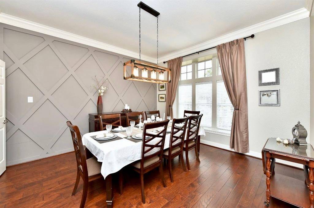 The dining room boasts engineered hardwood floors, a batten feature wall and luxe color selections and fixtures.