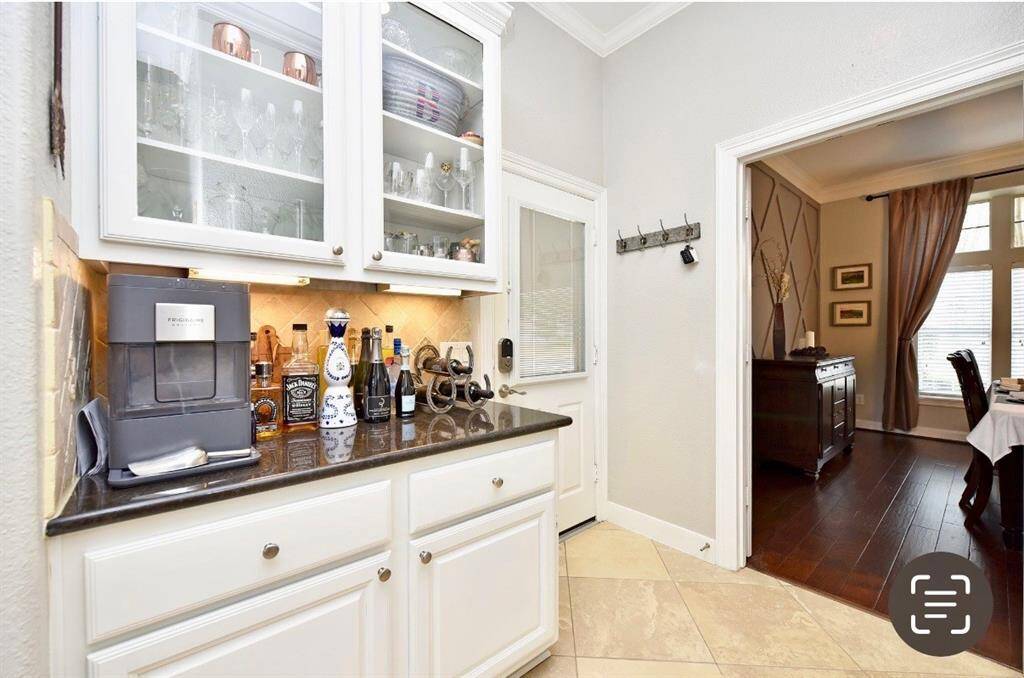 the butler's pantry is smartly located between the kitchen and formal dining room for dinner service or to top off cocktails.