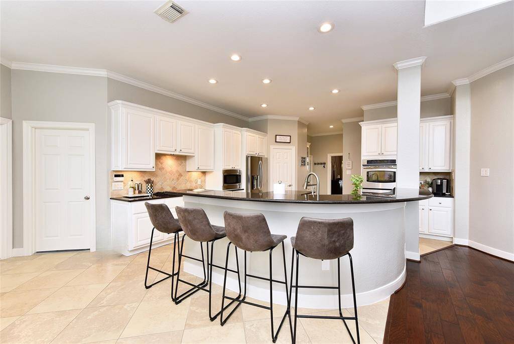 The kitchen features a breakfast bar and opens to the formal living room, perfect for entertaining.
