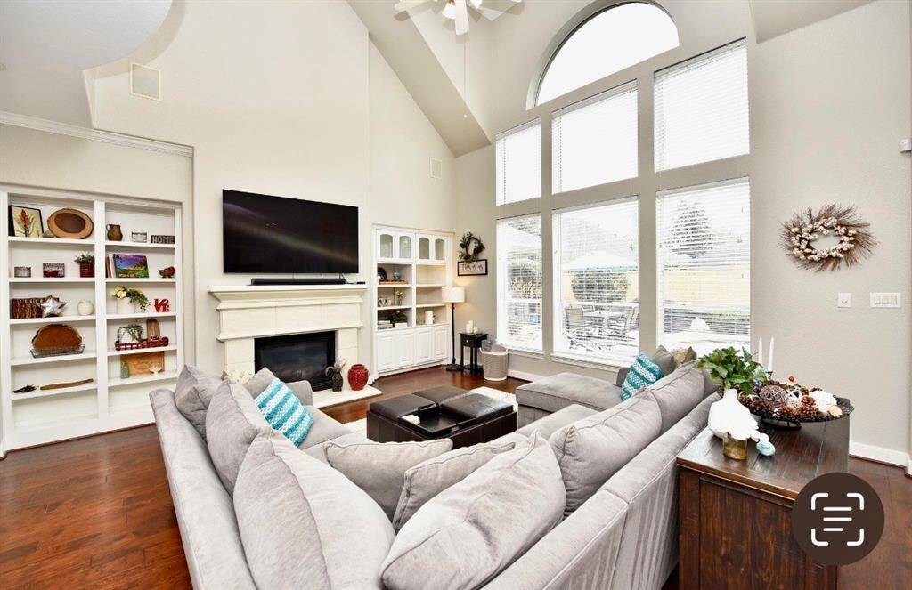 The living room features a bright atmospheric feel with a luxurious hardwood floors, soaring ceilings and inviting views of the gorgeous pool.