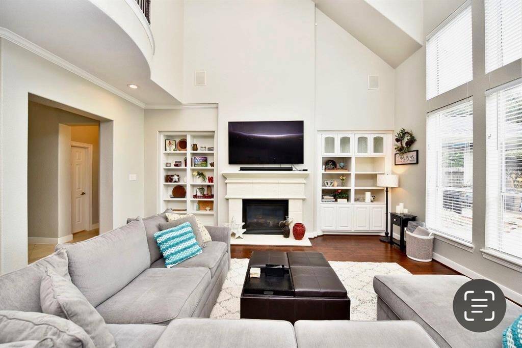 The living room features a bright atmospheric feel with a luxurious hardwood floors, soaring ceilings and inviting views of the gorgeous pool.