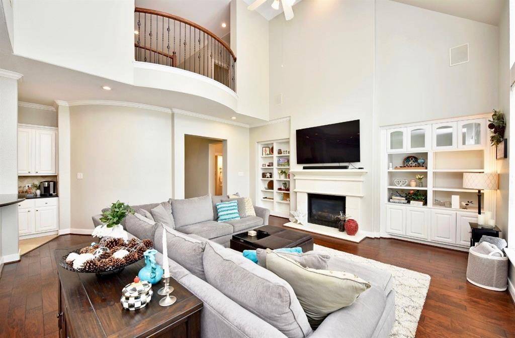 The living room features a bright atmospheric feel with a luxurious hardwood floors, soaring ceilings and inviting views of the gorgeous pool.