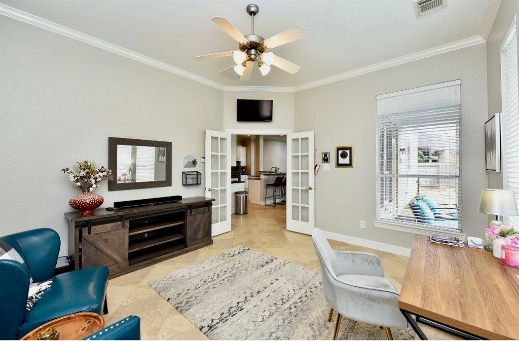 The flex room is perfect for a second office, library, or home gym with bright views of the backyard's pool and outdoor kitchen.
