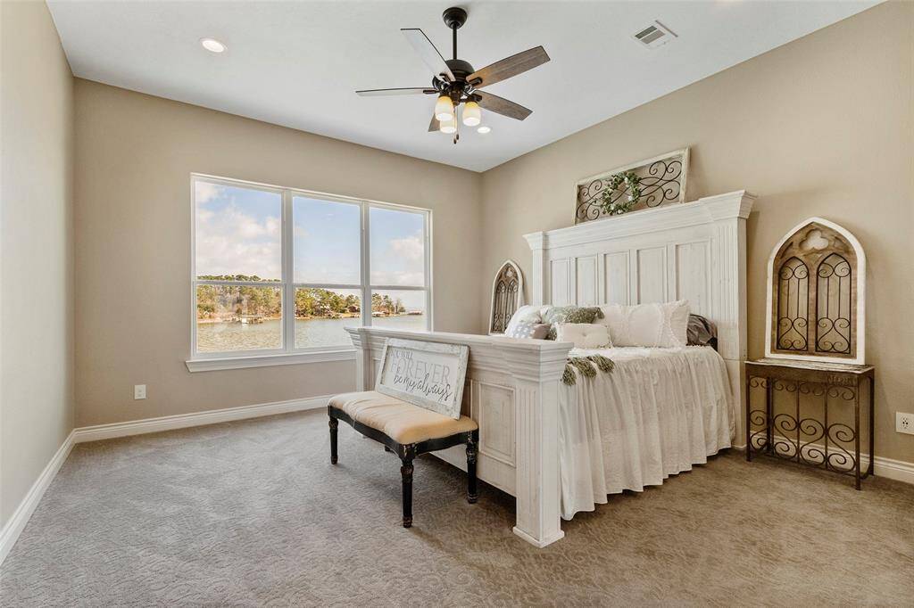 The primary bedrooms features a spectacular view of the lake. Complete with carpet, ceiling fan, and great closet space.