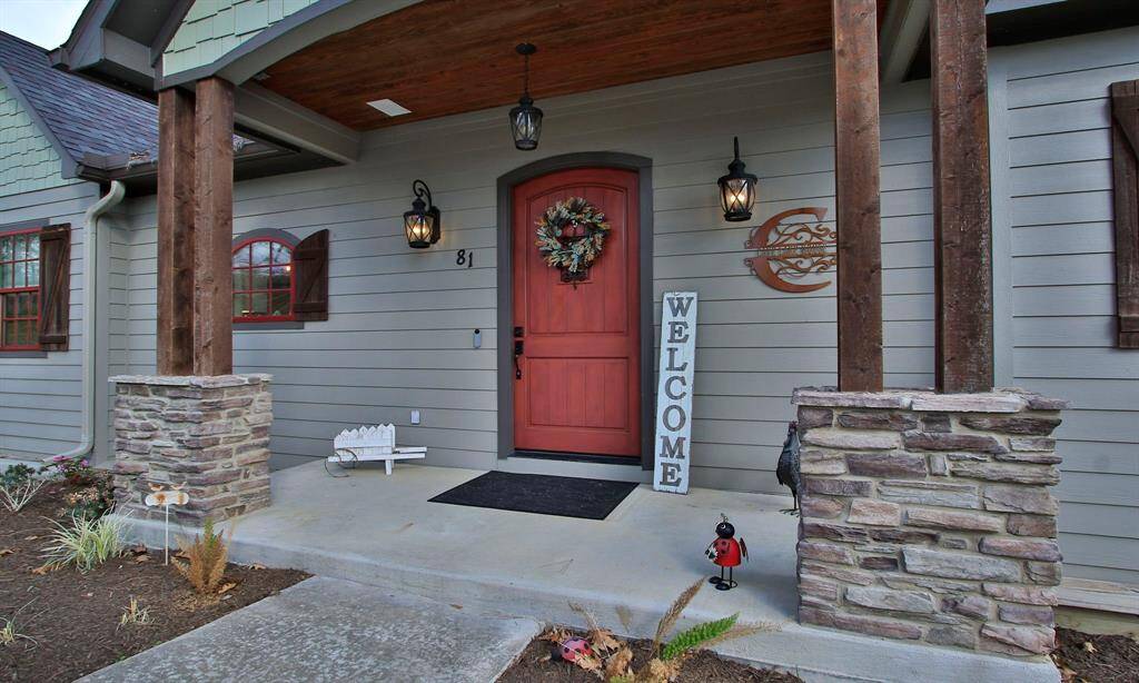 Charming front porch with a welcoming vibe, featuring stone accent columns and stylish lanterns. Perfect for greeting guests.