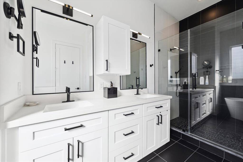 Primary bathrooms with dual sinks, ample storage, walk-in shower, and soaking tub.