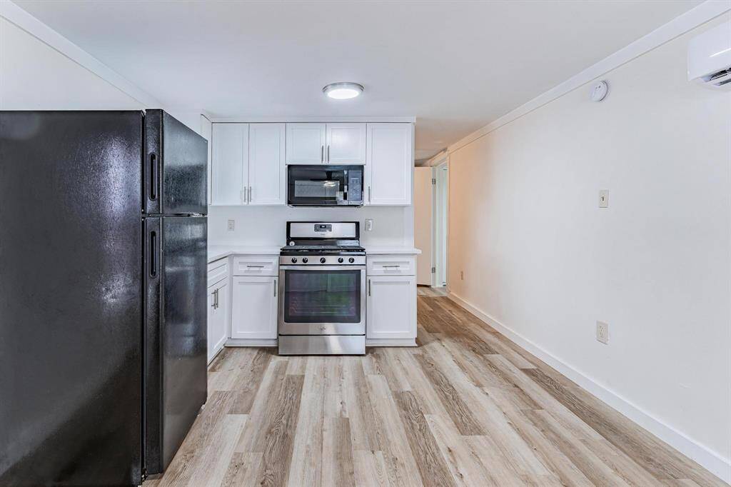 Chic duplex entry featuring modern kitchen amenities and sleek flooring, offering a welcoming and stylish first impression.