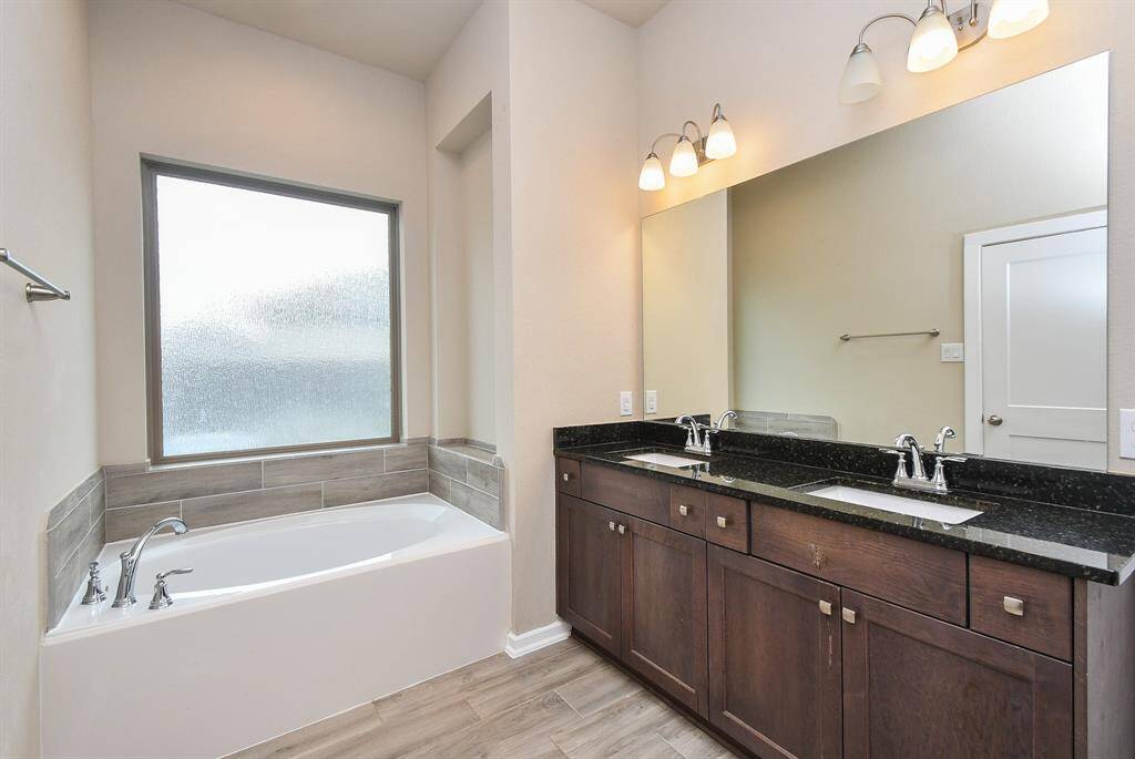 The master bathroom exudes luxury and relaxation, featuring a spa-like soaking tub as the centerpiece. A sleek vanity with ample counter space and elegant fixtures adds both style and functionality. Soft lighting and a neutral color palette enhance the serene ambiance, creating the perfect retreat for unwinding.